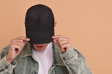 Photo of Man in stylish baseball cap on beige background. Mockup for design