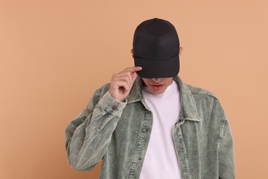 Photo of Man in stylish baseball cap on beige background. Mockup for design