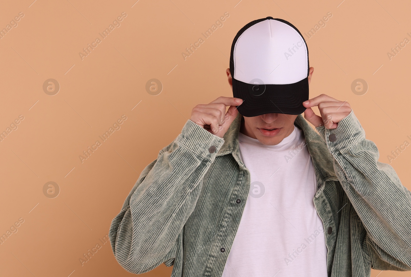 Photo of Man in stylish baseball cap on beige background. Mockup for design