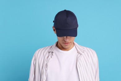 Photo of Man in stylish baseball cap on light blue background. Mockup for design