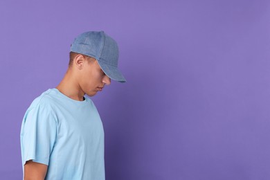 Photo of Man in stylish baseball cap on violet background. Mockup for design