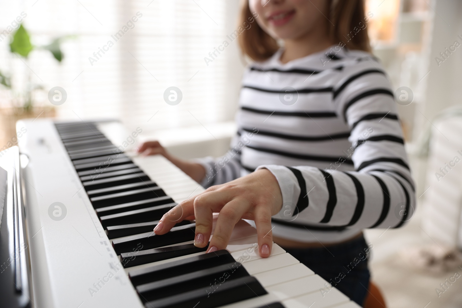 Photo of Girl playing synthesizer at home, closeup. Selective focus