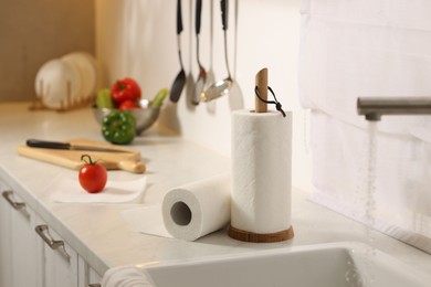 Photo of Rolls of paper towels on white marble countertop near sink in kitchen