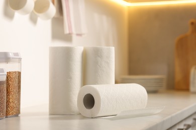 Photo of Rolls of paper towels on white marble countertop in kitchen