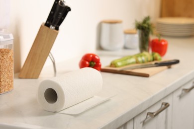 Photo of Roll of paper towels on white marble countertop in kitchen