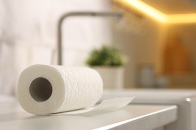 Photo of Roll of paper towels on white countertop in kitchen, closeup. Space for text