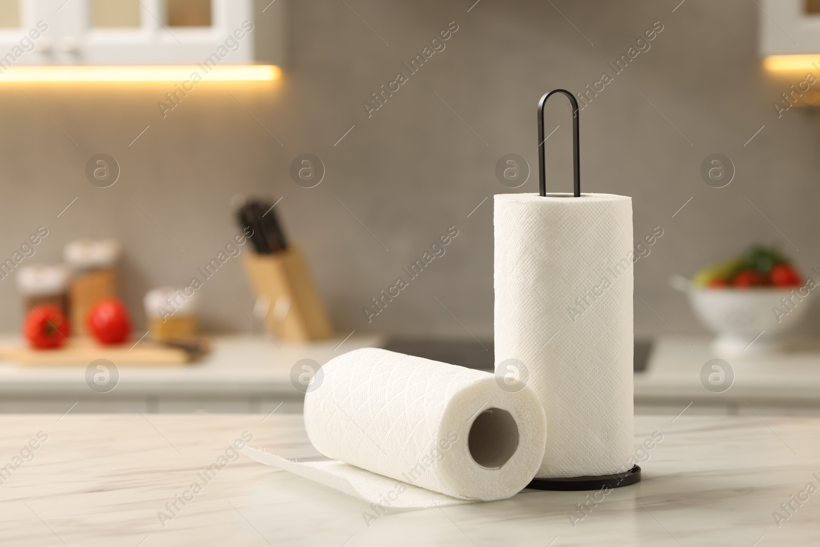 Photo of Rolls of paper towels on white marble table in kitchen