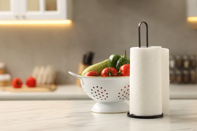 Photo of Roll of paper towels and vegetables on white marble table in kitchen, space for text