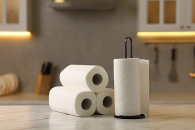 Photo of Rolls of paper towels on white marble table in kitchen