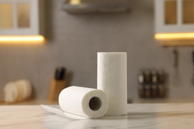 Photo of Rolls of paper towels on white marble table in kitchen