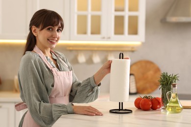 Photo of Woman using paper towels at white marble table in kitchen