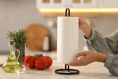 Photo of Woman using paper towels at white marble table in kitchen, closeup