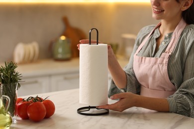 Photo of Woman using paper towels at white marble table in kitchen, closeup