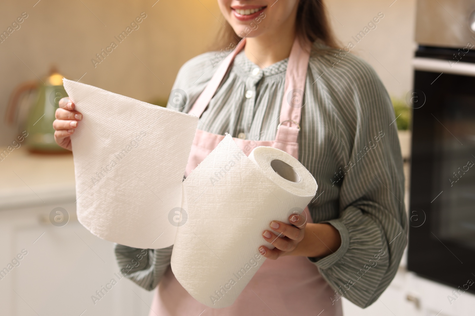 Photo of Woman using paper towels in kitchen, closeup