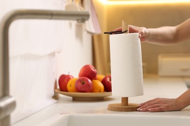 Photo of Woman using paper towels in kitchen, closeup