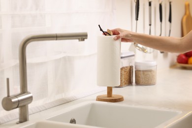 Photo of Woman using paper towels in kitchen, closeup