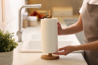 Photo of Woman using paper towels in kitchen, closeup