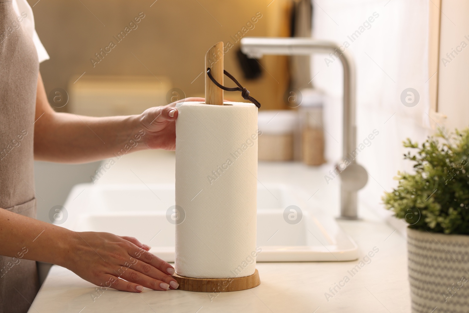 Photo of Woman using paper towels in kitchen, closeup