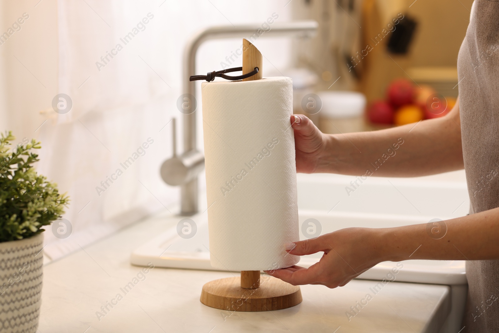 Photo of Woman using paper towels in kitchen, closeup