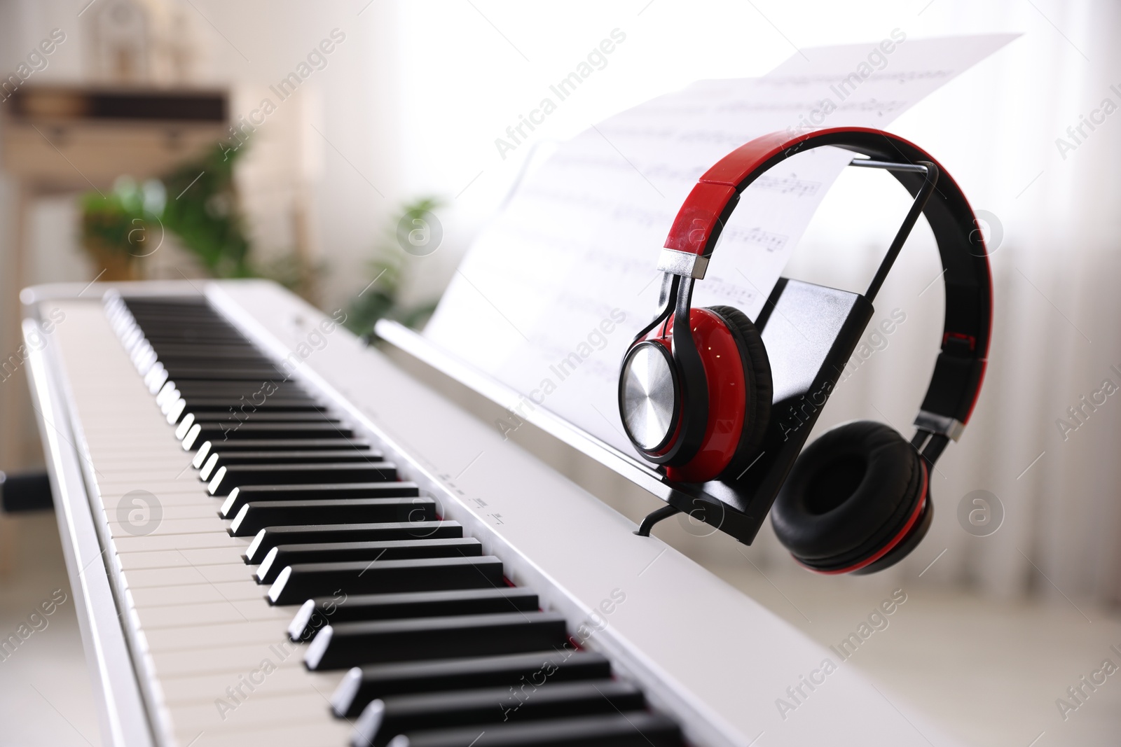 Photo of Synthesizer with music sheet and headphones indoors, closeup