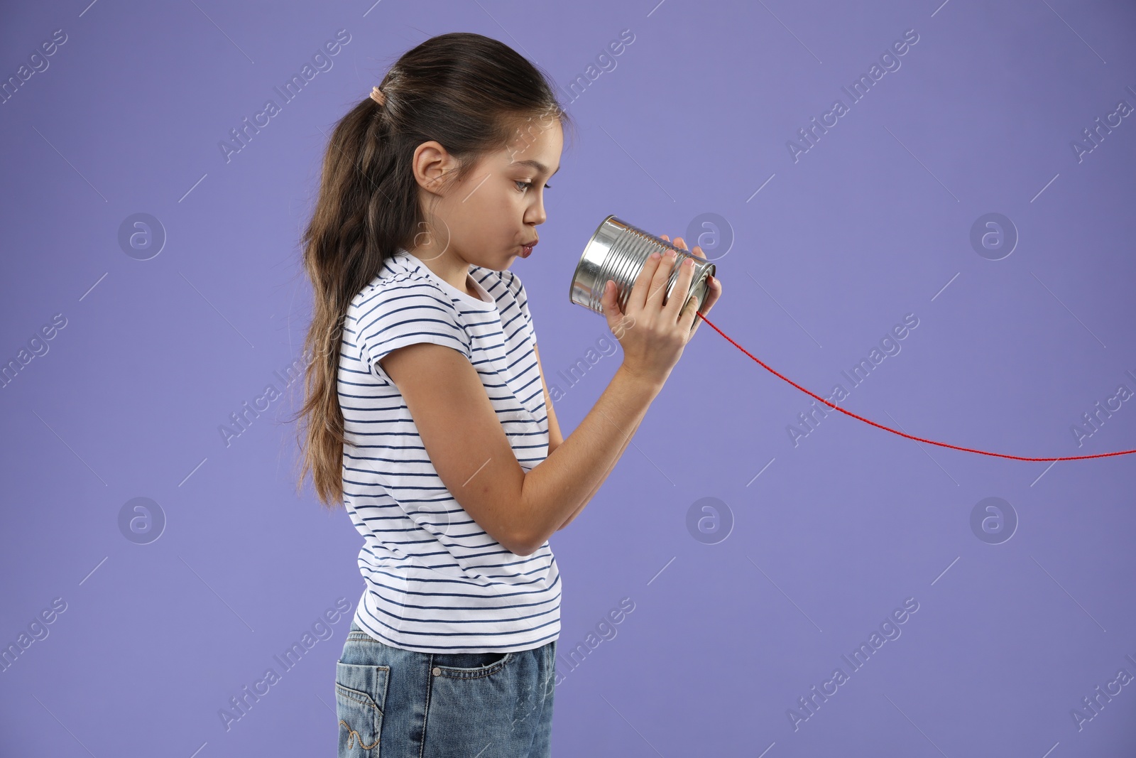 Photo of Girl using tin can telephone on violet background