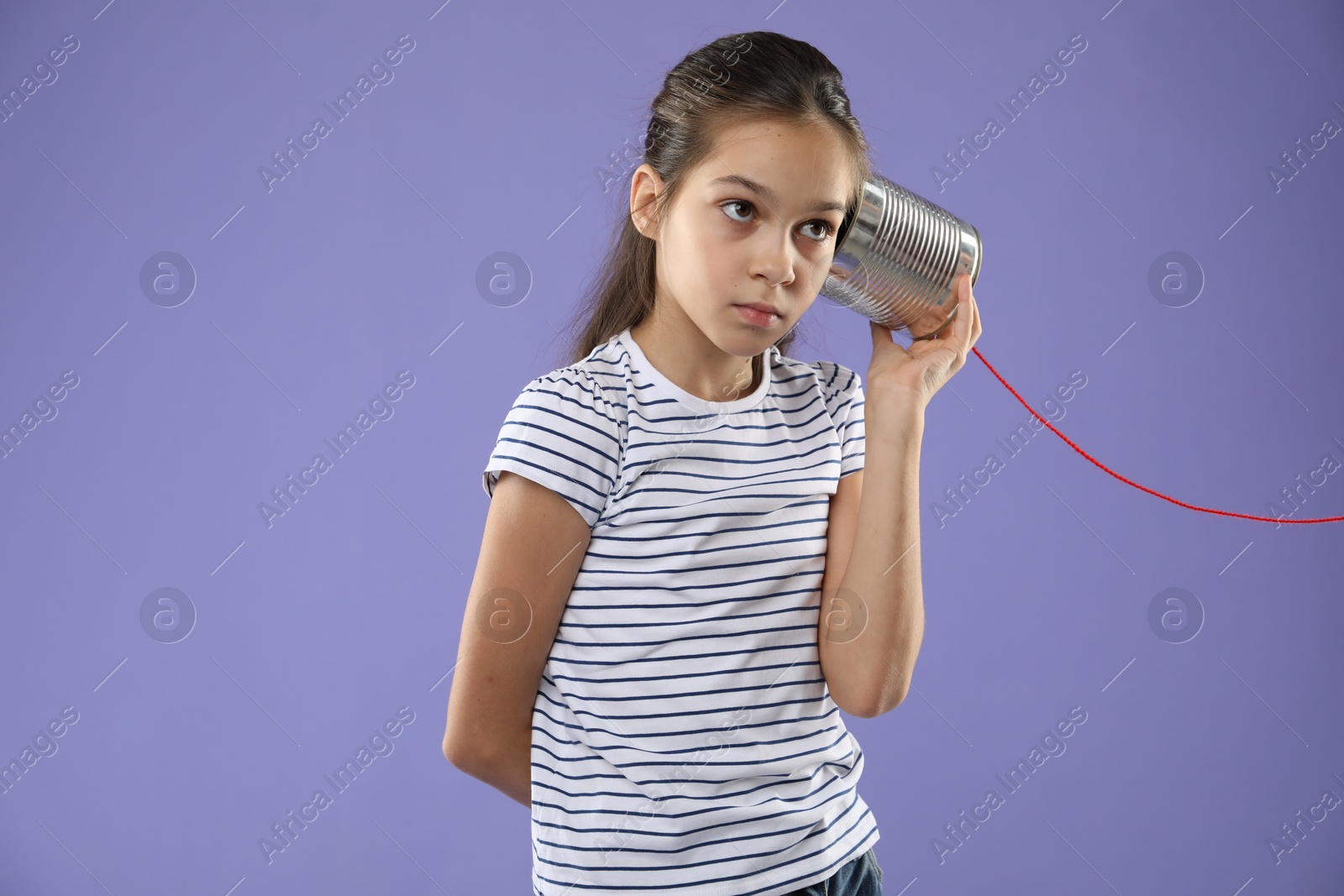 Photo of Girl using tin can telephone on violet background