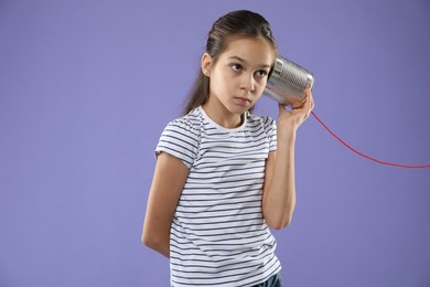 Photo of Girl using tin can telephone on violet background