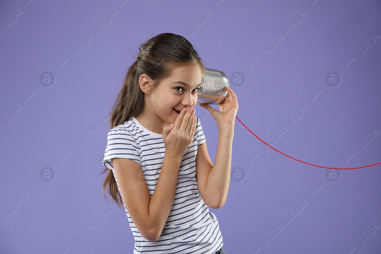 Photo of Girl using tin can telephone on violet background