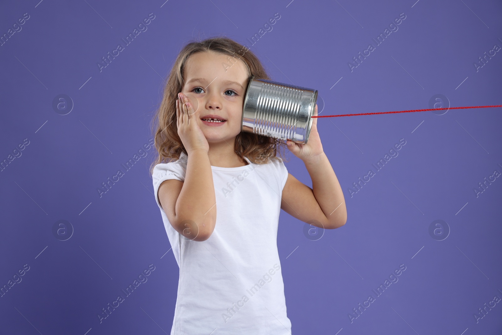 Photo of Girl using tin can telephone on violet background