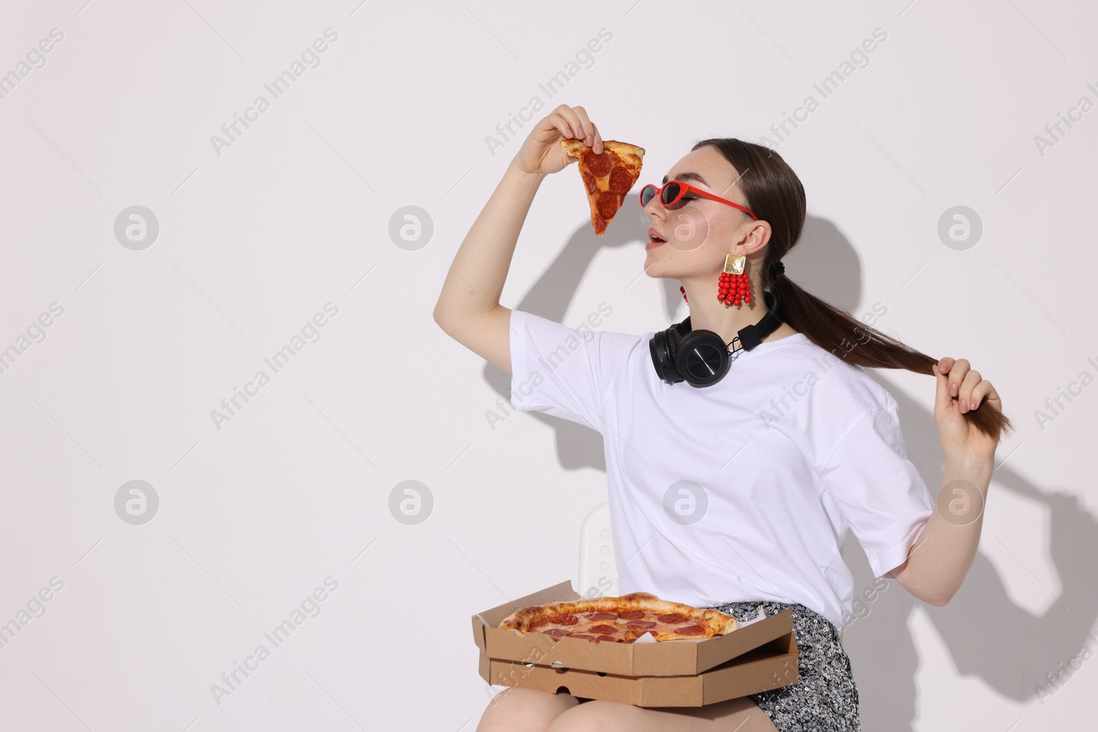 Photo of Woman in sunglasses with piece of pizza on white background, space for text