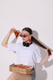 Photo of Woman in sunglasses with piece of pizza on white background, space for text