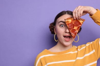 Photo of Emotional woman with piece of delicious pizza on violet background, space for text