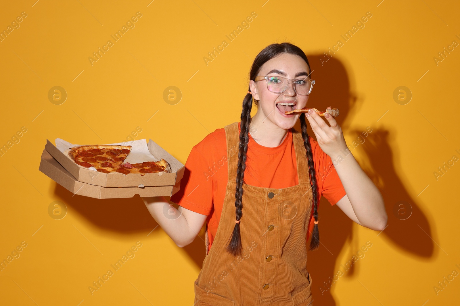 Photo of Beautiful woman with delicious pizza on orange background