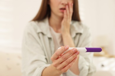 Woman with negative pregnancy test at home, closeup