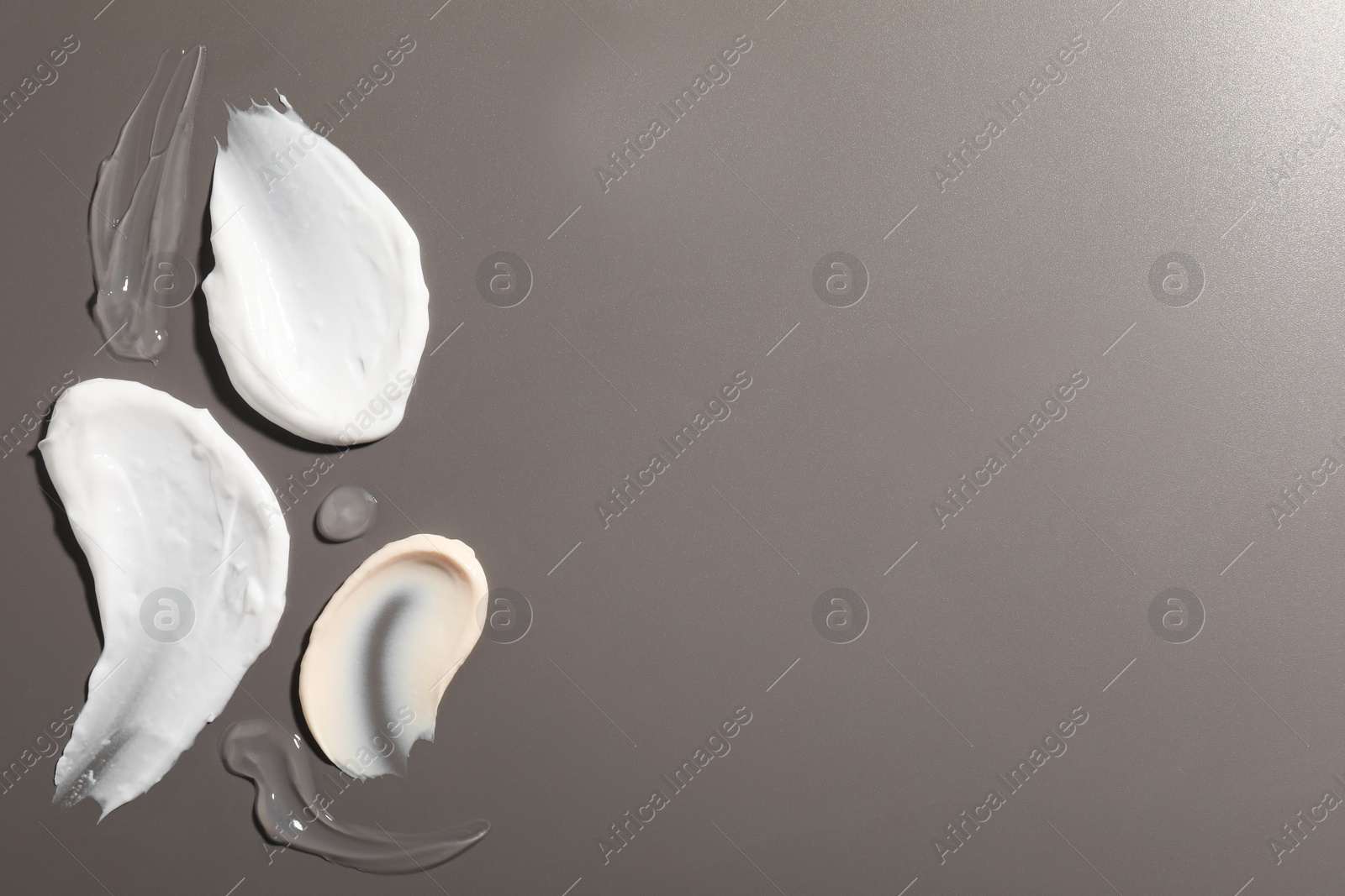 Photo of Samples of different cosmetic products on grey background, flat lay. Space for text