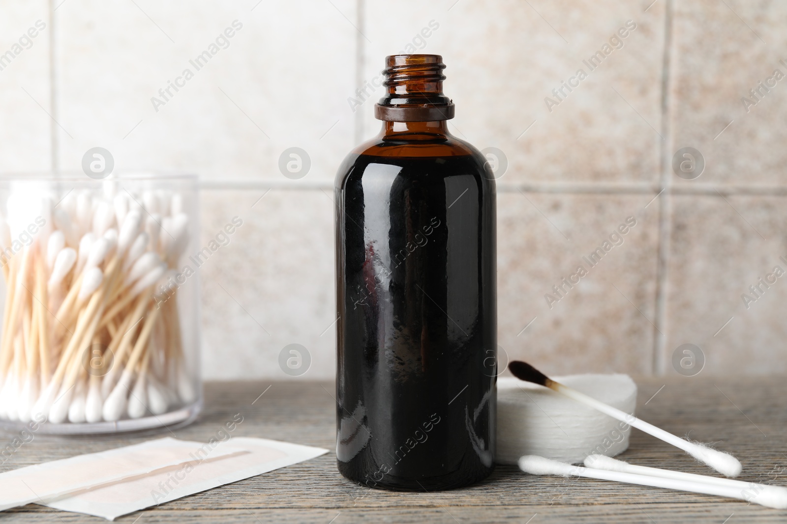 Photo of Topical iodine, cotton pads, swabs and adhesive bandages on wooden table