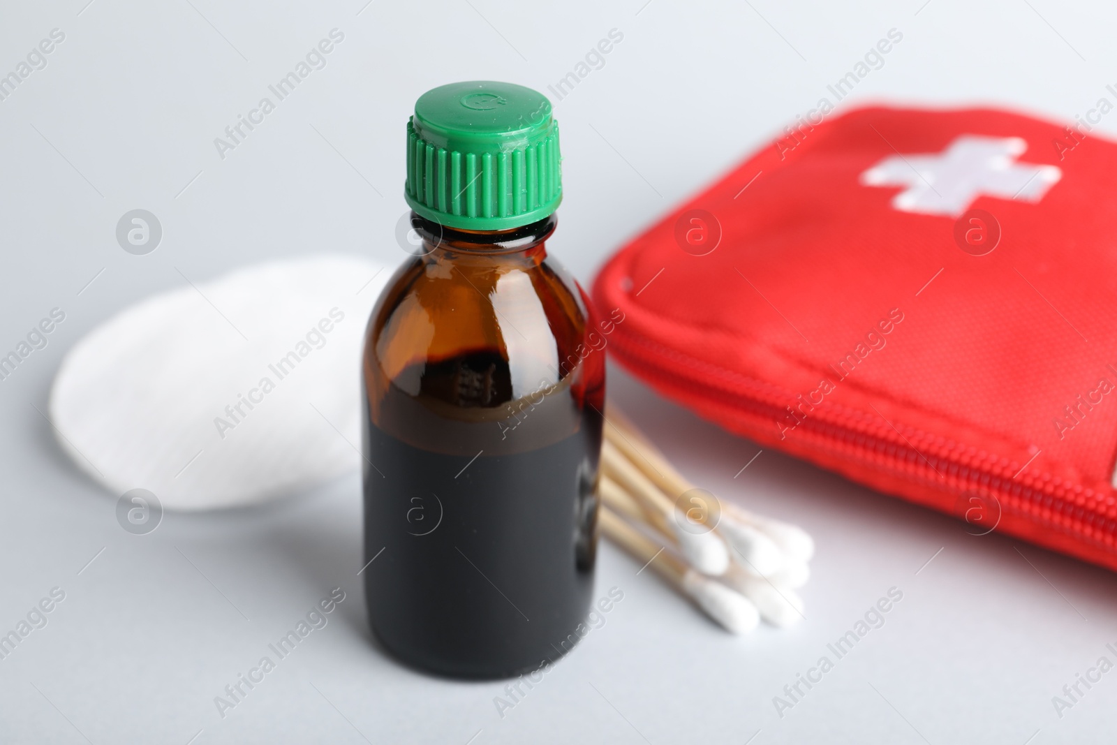 Photo of Topical iodine and other first aid kit components on light background, closeup