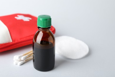 Photo of Topical iodine and other first aid kit components on light background, closeup