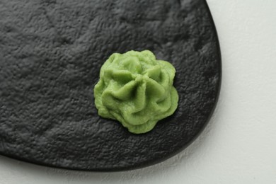 Photo of Slate board with hot wasabi paste on light textured table, top view