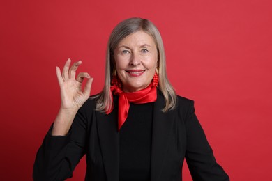 Photo of Senior woman showing okay gesture on red background