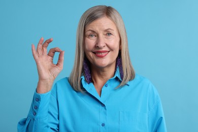 Photo of Senior woman showing okay gesture on blue background