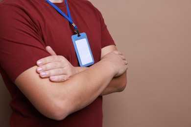 Photo of Man with blank badge on brown background, closeup. Space for text