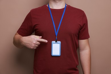 Photo of Man with blank badge on brown background, closeup