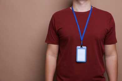 Photo of Man with blank badge on brown background, closeup. Space for text