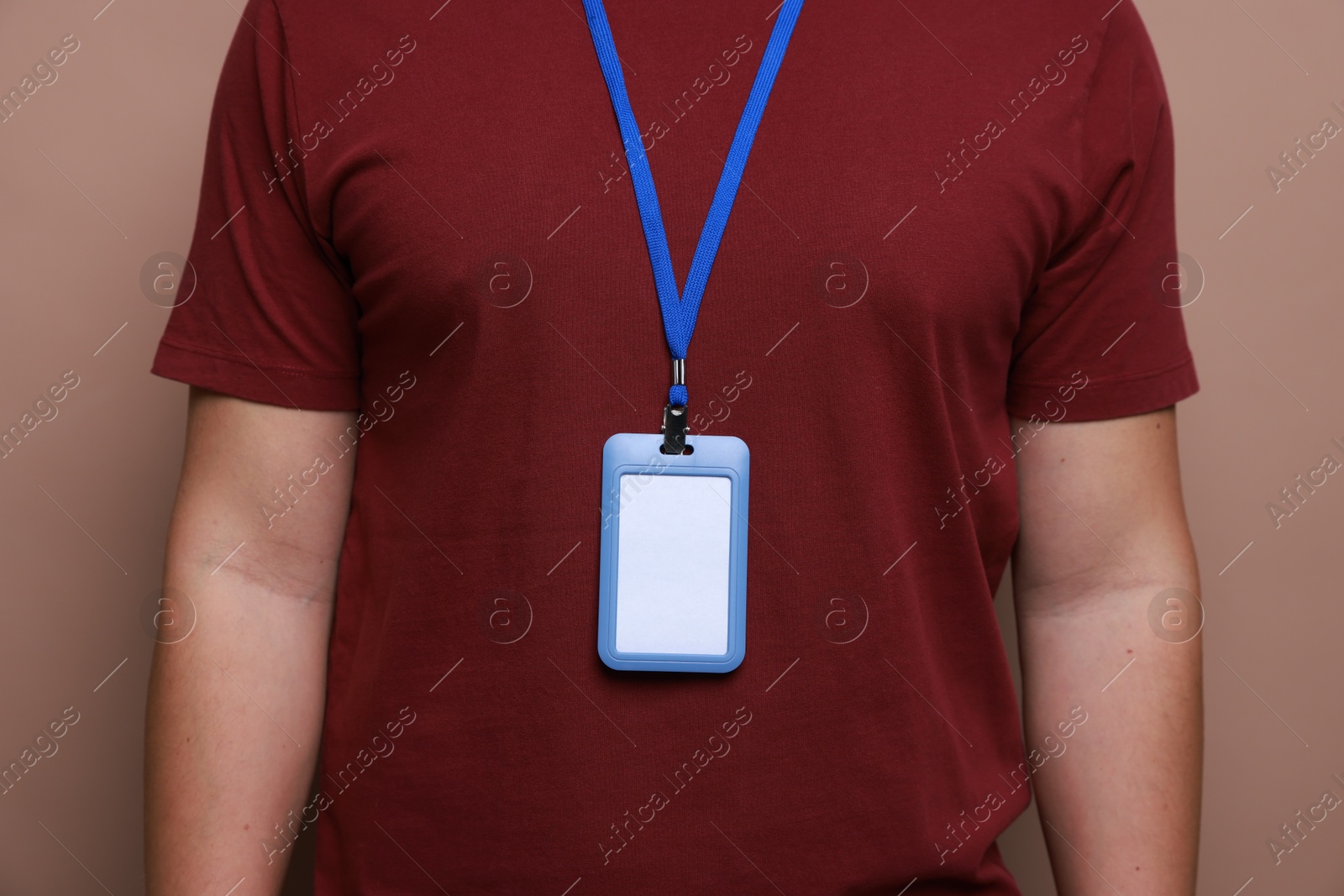 Photo of Man with blank badge on brown background, closeup