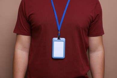 Photo of Man with blank badge on brown background, closeup