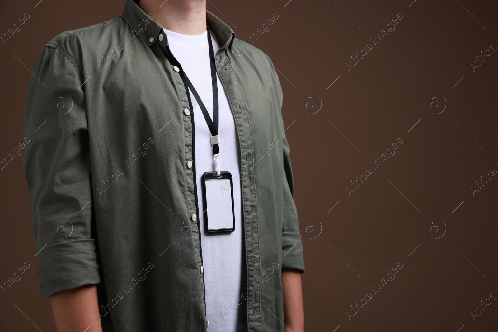 Photo of Man with blank badge on brown background, closeup