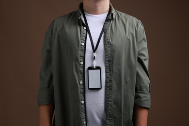 Photo of Man with blank badge on brown background, closeup