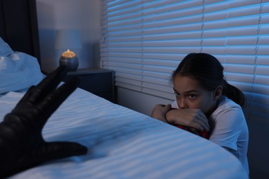 Photo of Bogeymen reaching for scared girl in bedroom at night, closeup