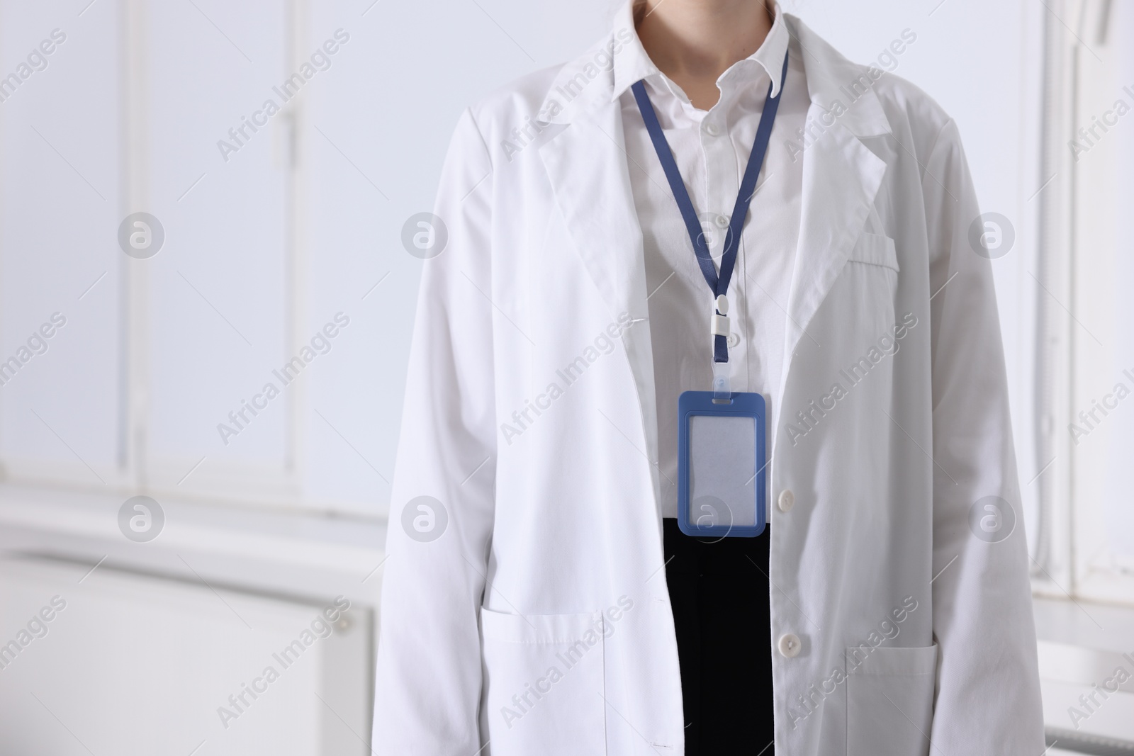 Photo of Doctor with badge in clinic, closeup. Space for text